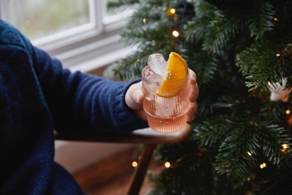 Sitheny Glass In Hand With Orange And Christmas Tree