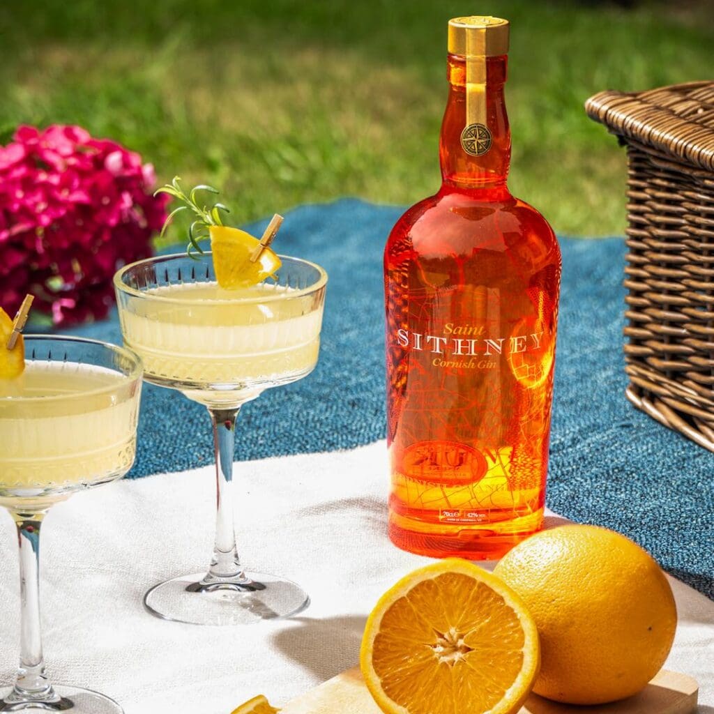 Sithney A Bottle Of Orange Juice Next To A Glass Of Lemon Juice