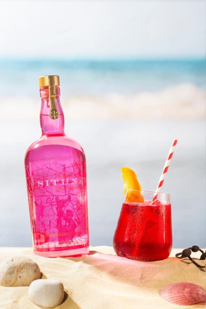 Sithney A Bottle Of Pink Cocktail Next To A Glass Of Pink Cocktail