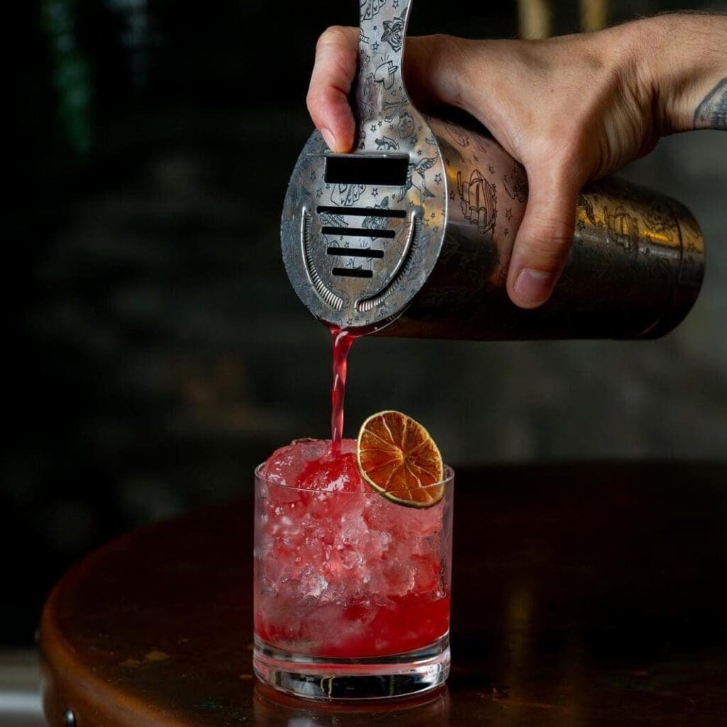 Sithney Pouring Cocktail Into Glass