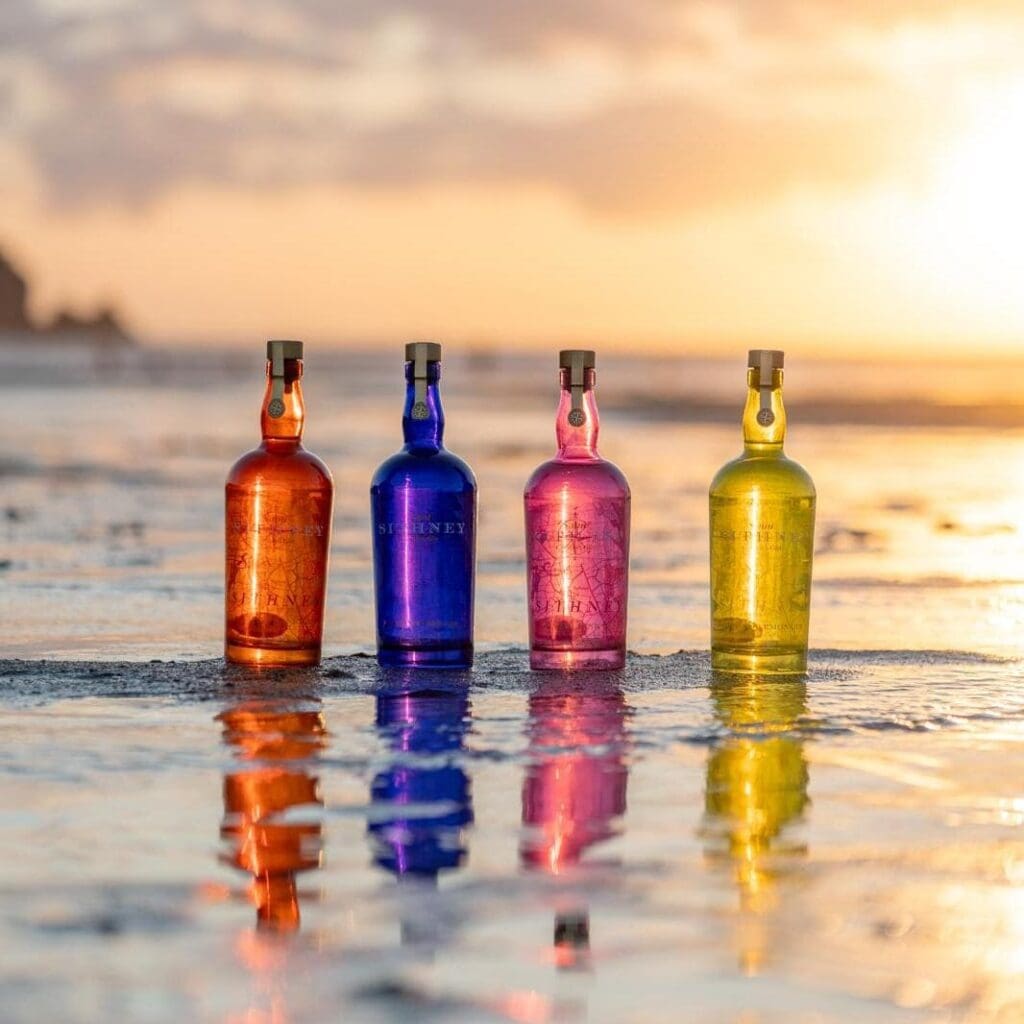Saint Sithney Gin Bottles On Beach At Sunset